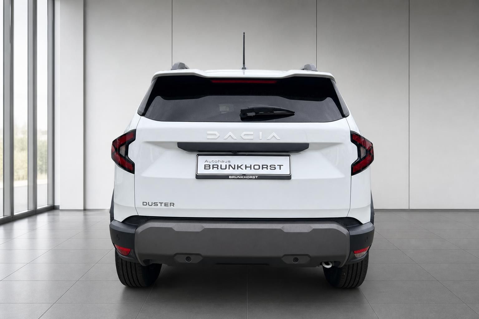 Dacia Duster weiß Heckansicht mit Kennzeichen Autohaus Brunkhorst im Showroom