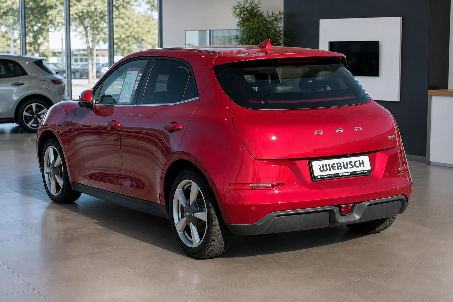 Roter ORA SUV Heckansicht im Autohaus-Showroom mit modernem Design und Alufelgen