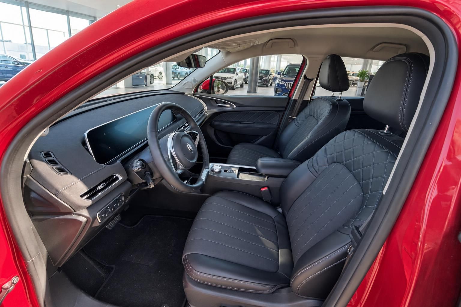 Geräumiger Innenraum mit schwarzen Ledersitzen und modernem Dashboard im roten ORA SUV