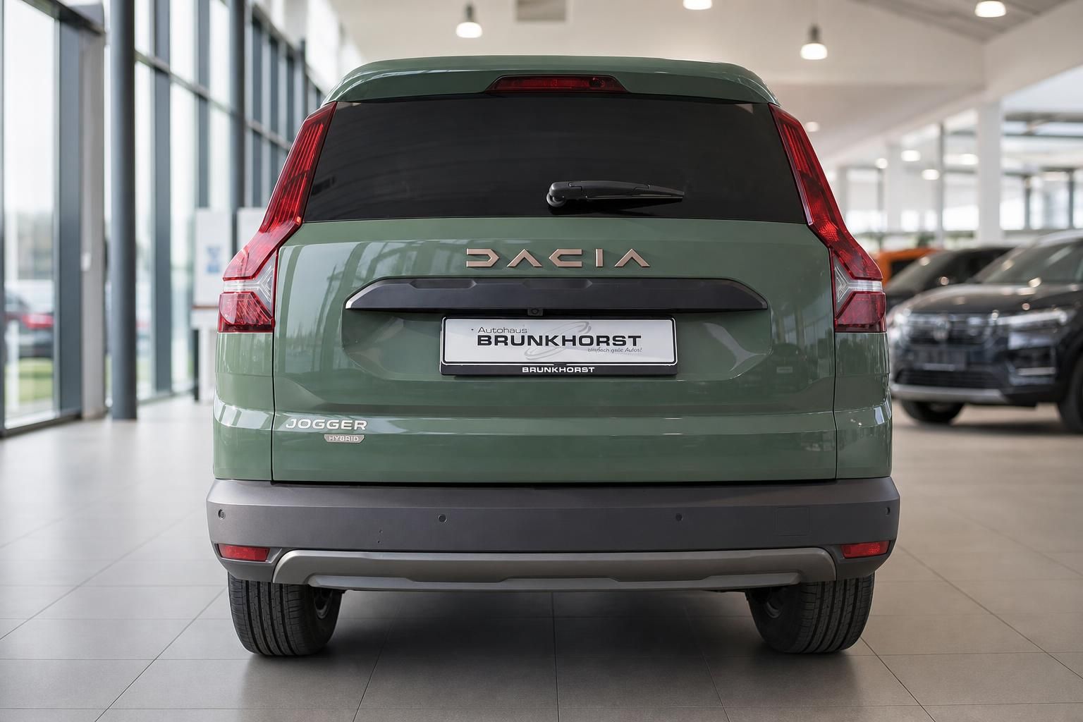 Dacia Jogger Hybrid Heckansicht in grün mit DACIA Schriftzug und Händlerkennzeichen