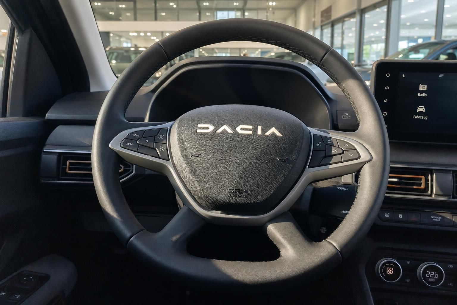 Dacia Fahrzeug Innenraum mit Lenkrad und Infotainment-Display im Autohaus Showroom