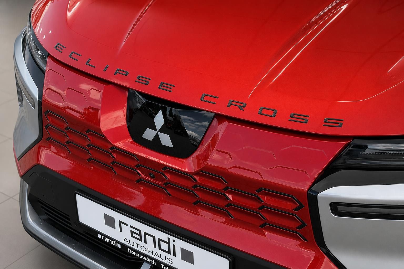 Mitsubishi Eclipse Cross Frontansicht in Rot mit Markenlogo und Modellschriftzug auf der Motorhaube