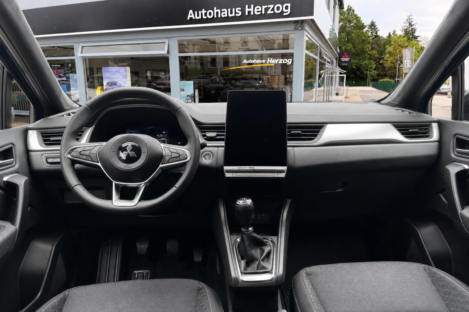 Mitsubishi Cockpit-Ansicht - Lenkrad, Touchscreen und Schaltknauf im modernen Innenraum