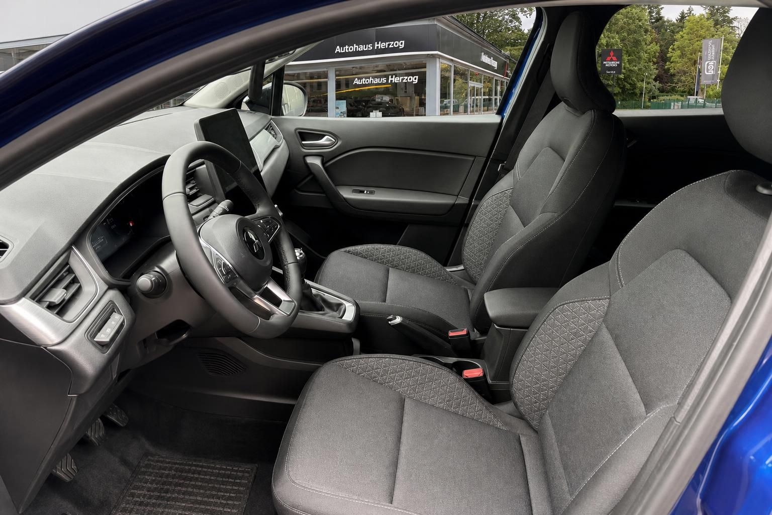 Mitsubishi SUV Innenraum - graue Stoffsitze, Lenkrad und Armaturenbrett Fahrerseite