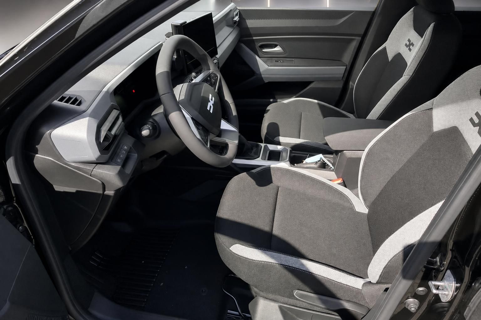 Dacia Fahrerplatz mit Sportsitzen und modernem Lenkrad im Innenraum