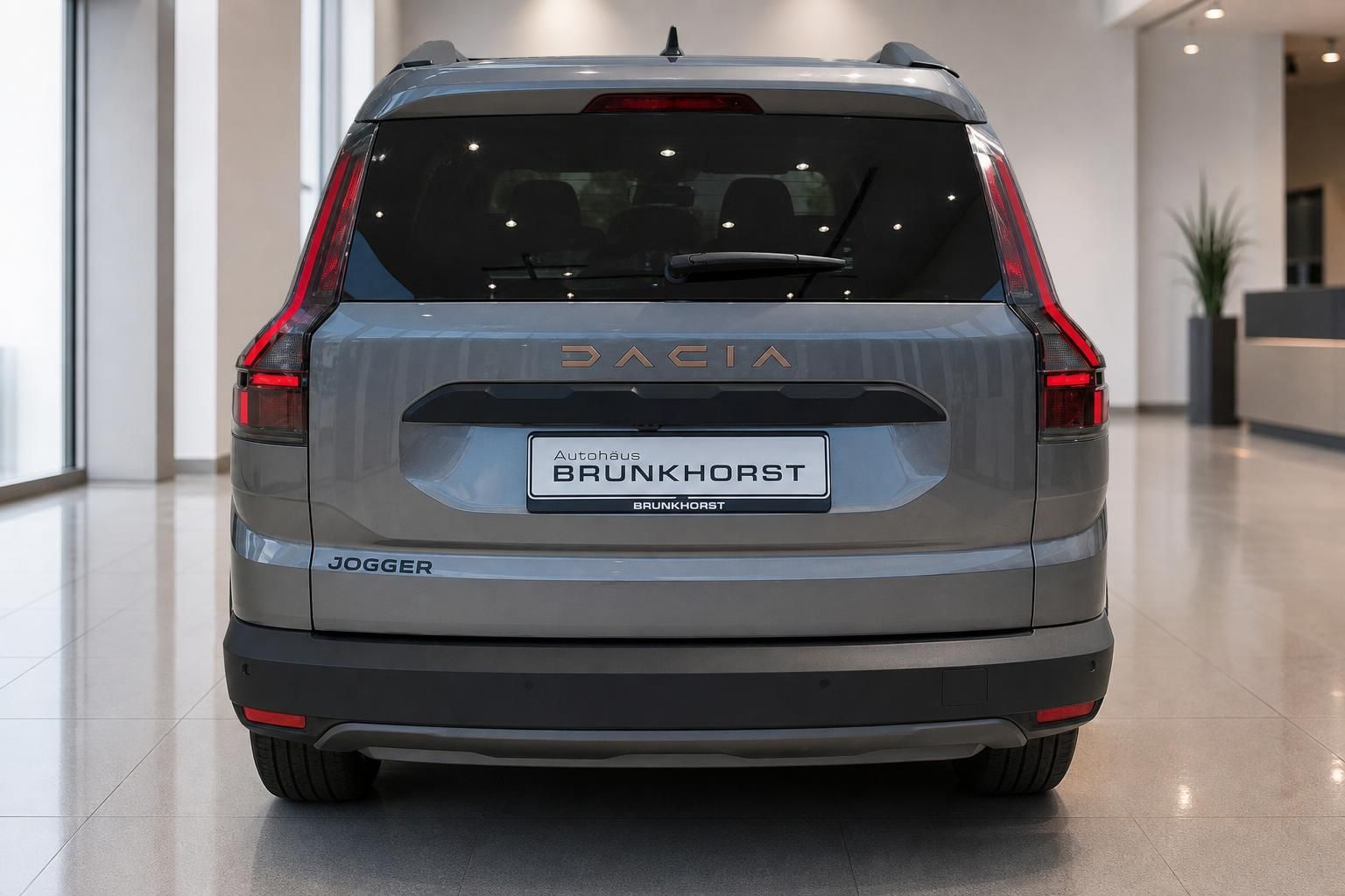 Dacia Jogger Heckansicht in grau mit roten Rücklichtern und Autohaus Brunkhorst Kennzeichen