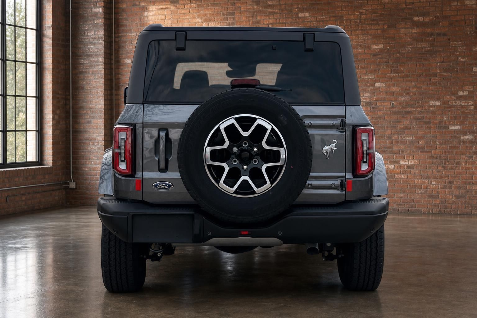 Ford Bronco Heckansicht mit Reserverad und Ford Logo im Showroom
