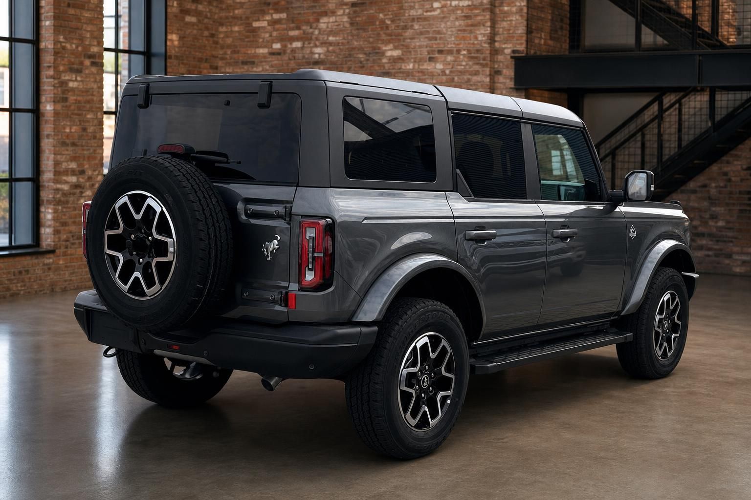 Ford Bronco grau Heck-Seitenansicht mit Reserverad und Offroad-Reifen