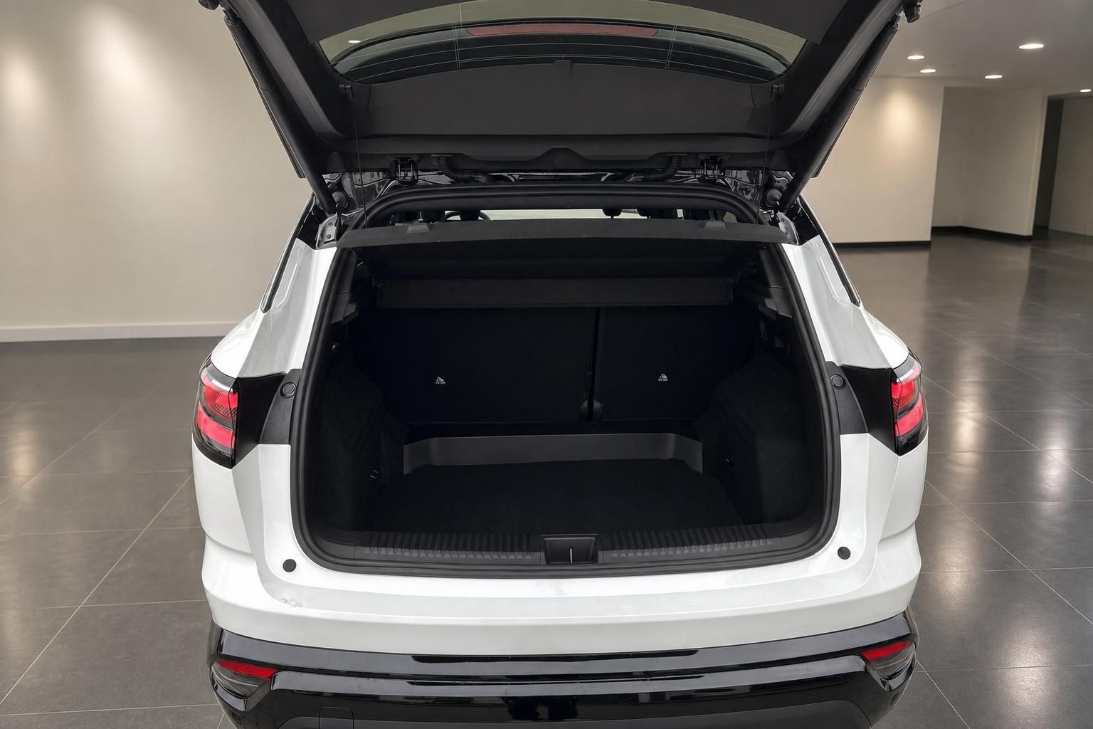 Weißer SUV mit geöffnetem Kofferraum zeigt großzügigen Laderaum im Autohaus-Showroom