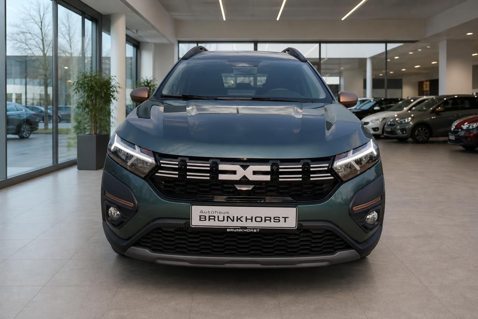 Dacia SUV Frontansicht in grüner Lackierung mit charakteristischem X-Design im Kühlergrill