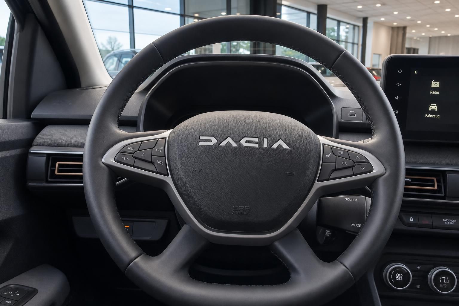 Dacia Fahrzeug Innenraum mit schwarzem Lenkrad und modernem Infotainment-Display