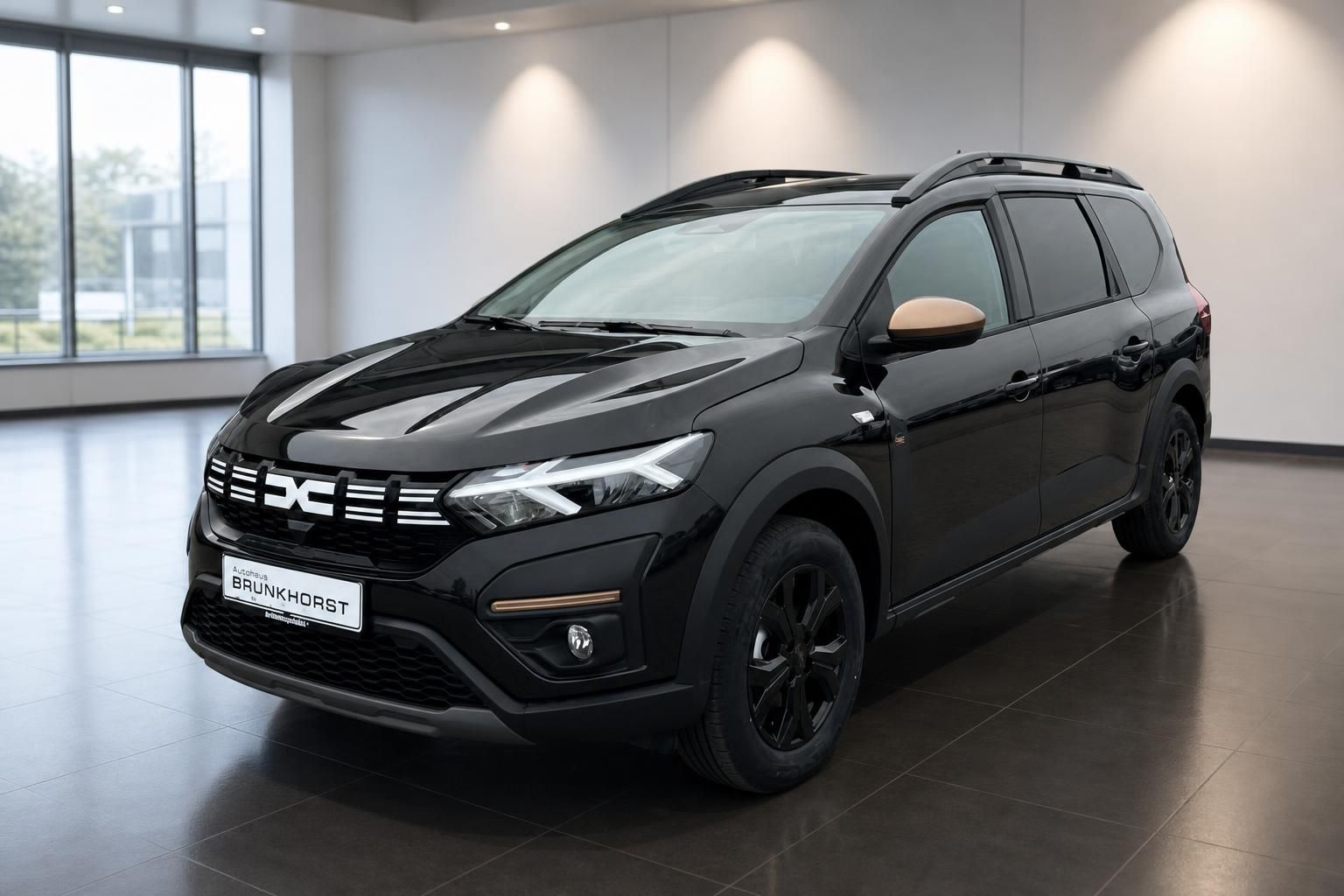 Dacia SUV in schwarzer Lackierung - Frontansicht im modernen Autohaus-Showroom mit Glasfront