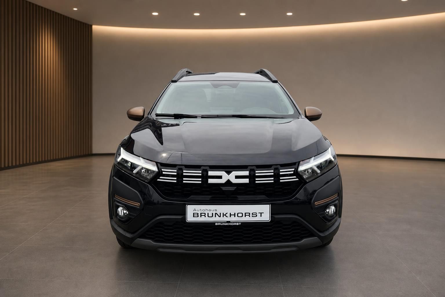 Dacia SUV Frontansicht schwarz - modernes Design mit LED-Scheinwerfern im stilvollen Showroom