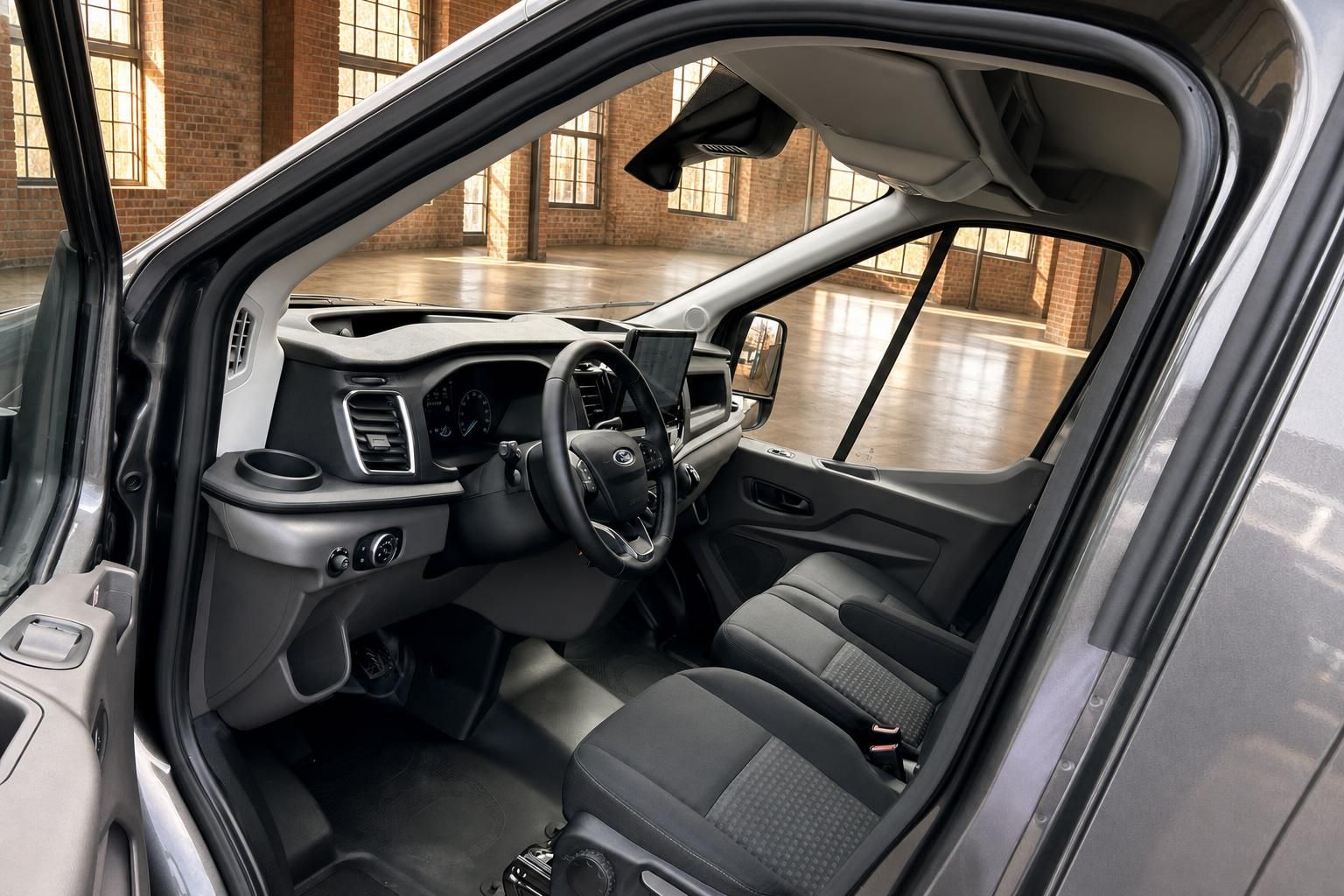 Ford Transit Innenraum – Fahrerseite mit Lenkrad, Armaturenbrett, Touchscreen und Fahrersitz