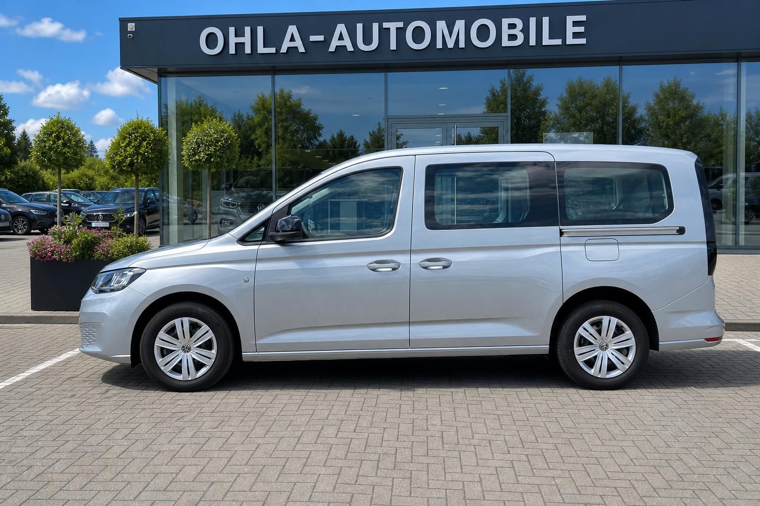 VW Caddy silber Seitenansicht auf Hof des Autohauses
