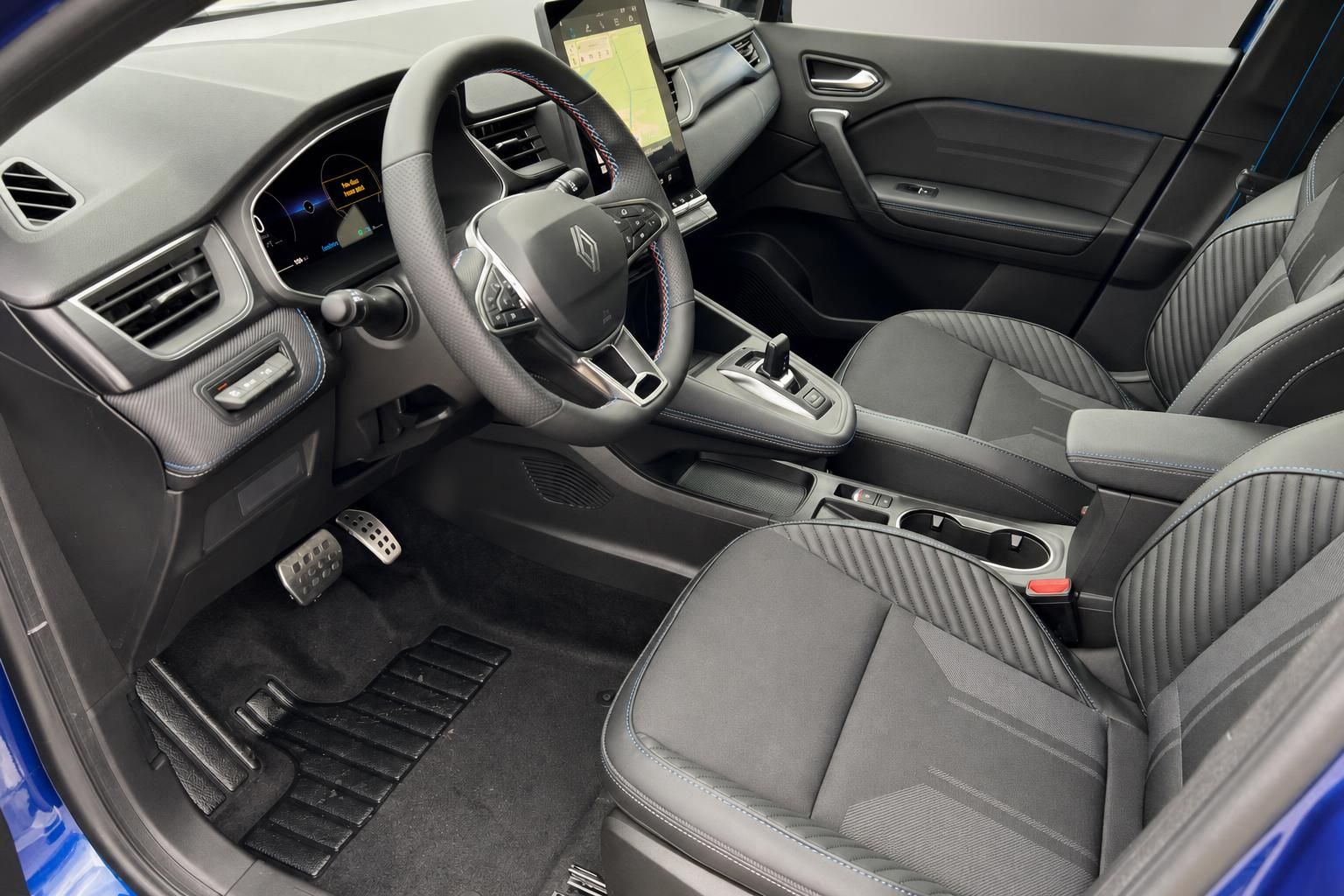 Moderner Fahrzeuginnenraum mit Ledersitzen, Touchscreen-Display und sportlichem Lenkrad in Grau-Schwarz