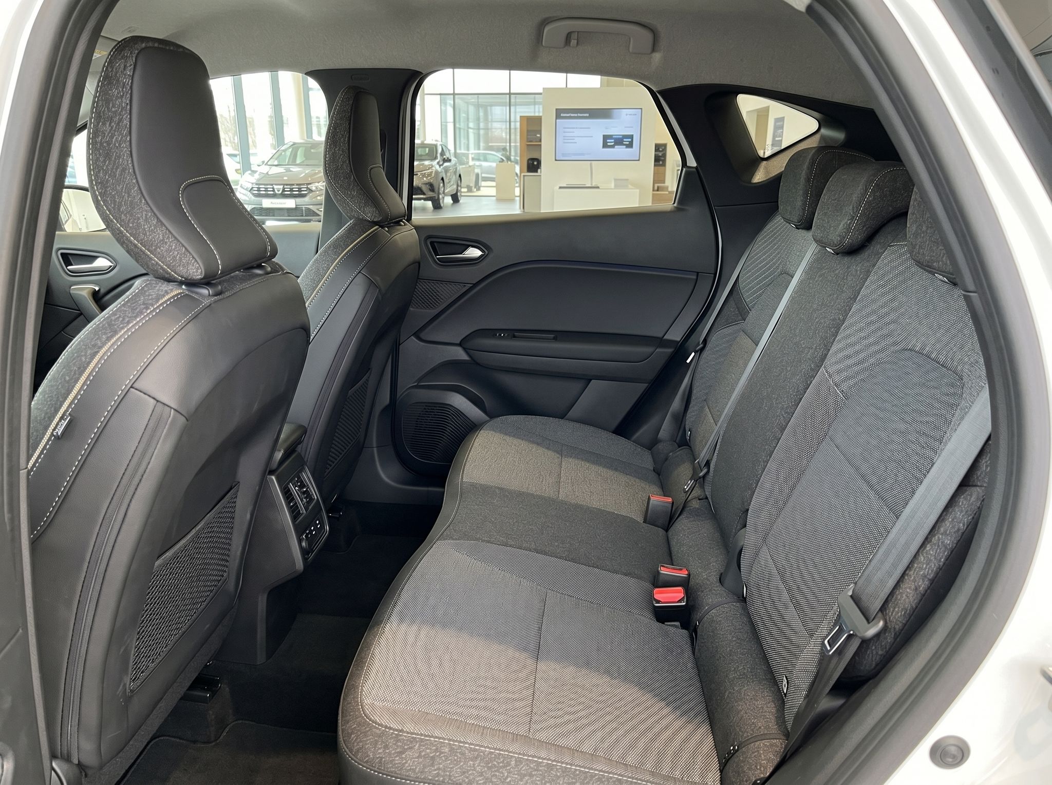 Renault Rücksitzbank mit grauen Stoffsitzen und Sicherheitsgurten im Fahrzeuginnenraum