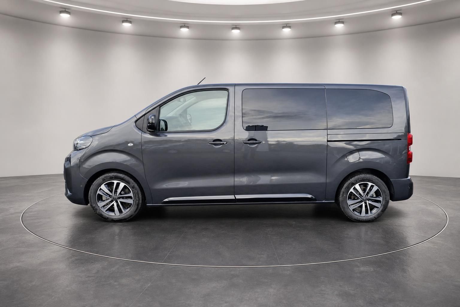 Grauer Transporter Van Seitenansicht im Showroom mit professioneller Beleuchtung