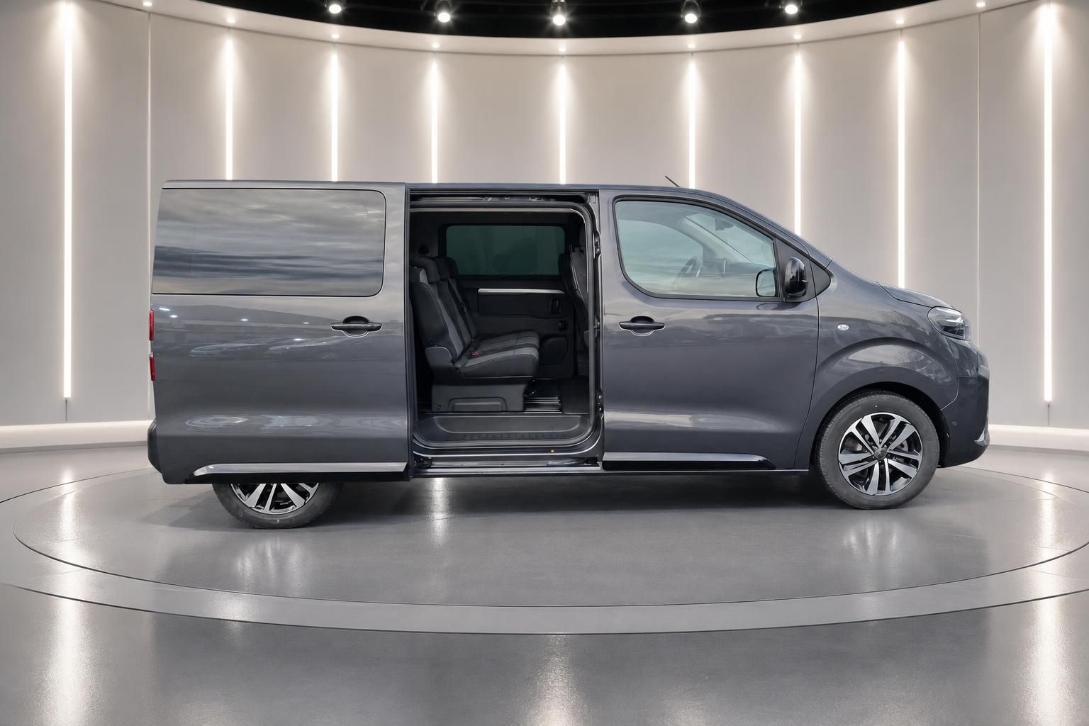 Grauer Peugeot Traveller Van mit geöffneter Seitentür zeigt Innenraum und Sitze im Showroom