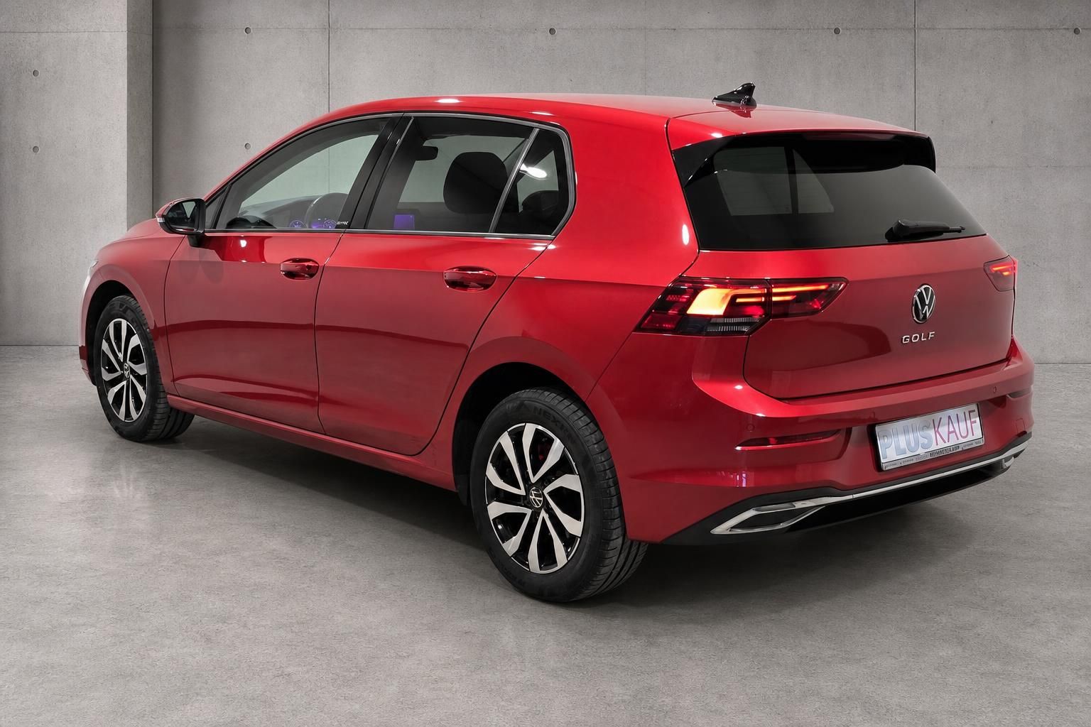 VW Golf 8 in Rot, Heckansicht schraeg mit Golf Schriftzug