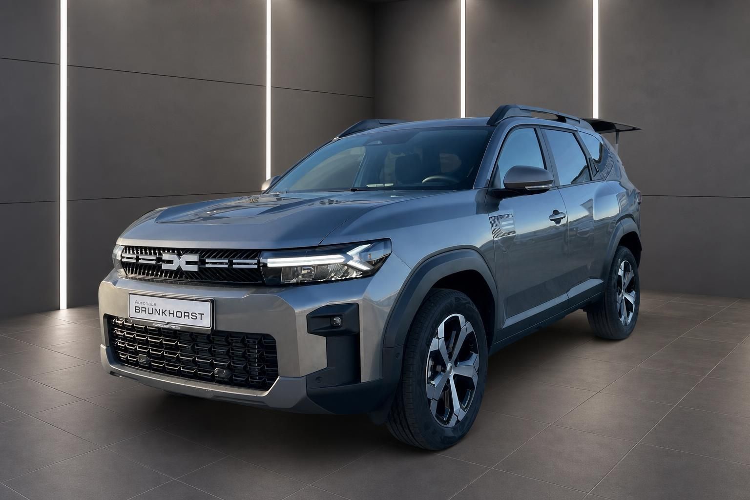 Dacia SUV in grau seitliche Dreiviertelansicht im modernen Showroom
