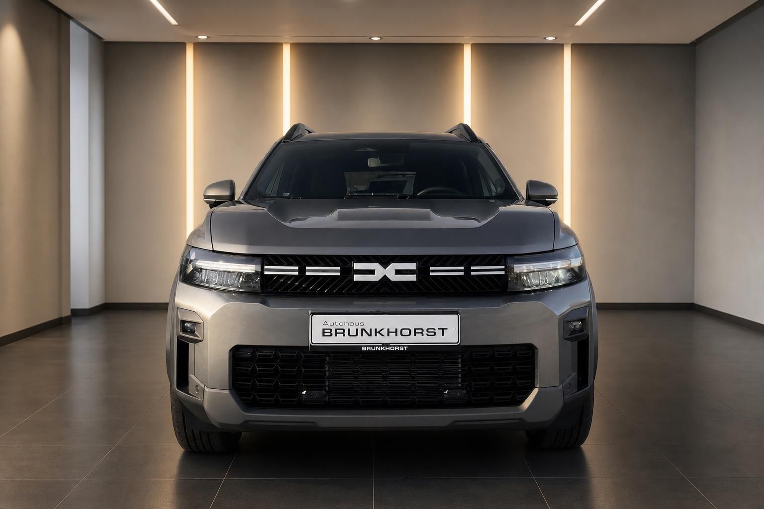Dacia SUV Frontansicht in grau im modernen Autohaus-Showroom
