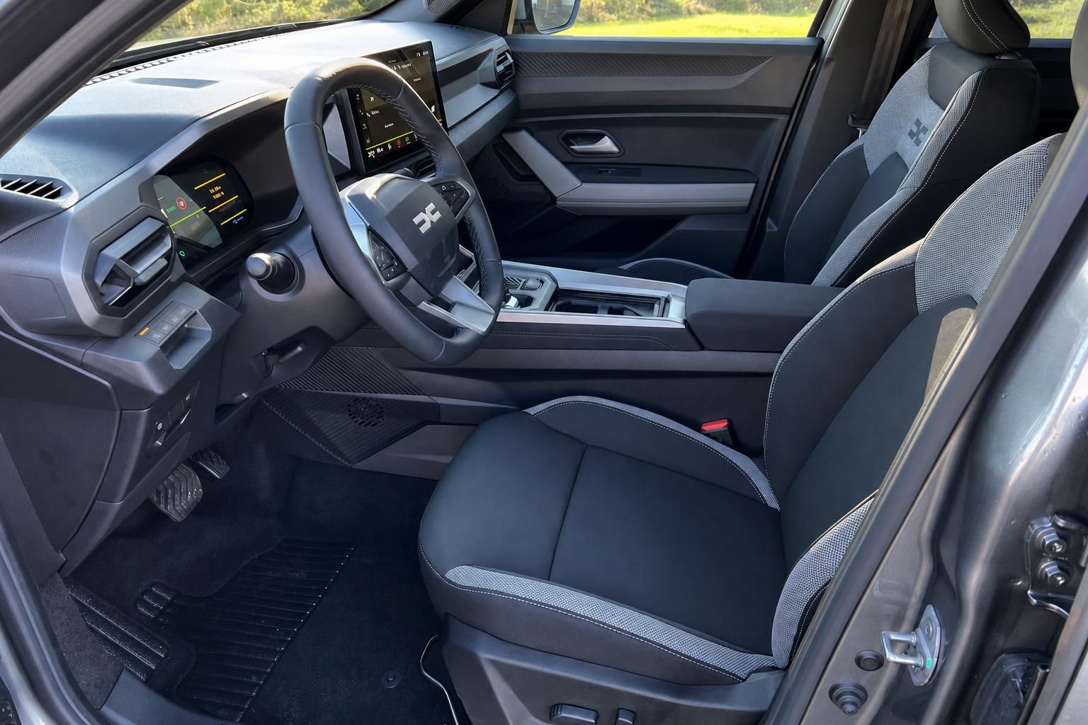Dacia Fahrersitz und Cockpit mit Lenkrad und Armaturenbrett in grau