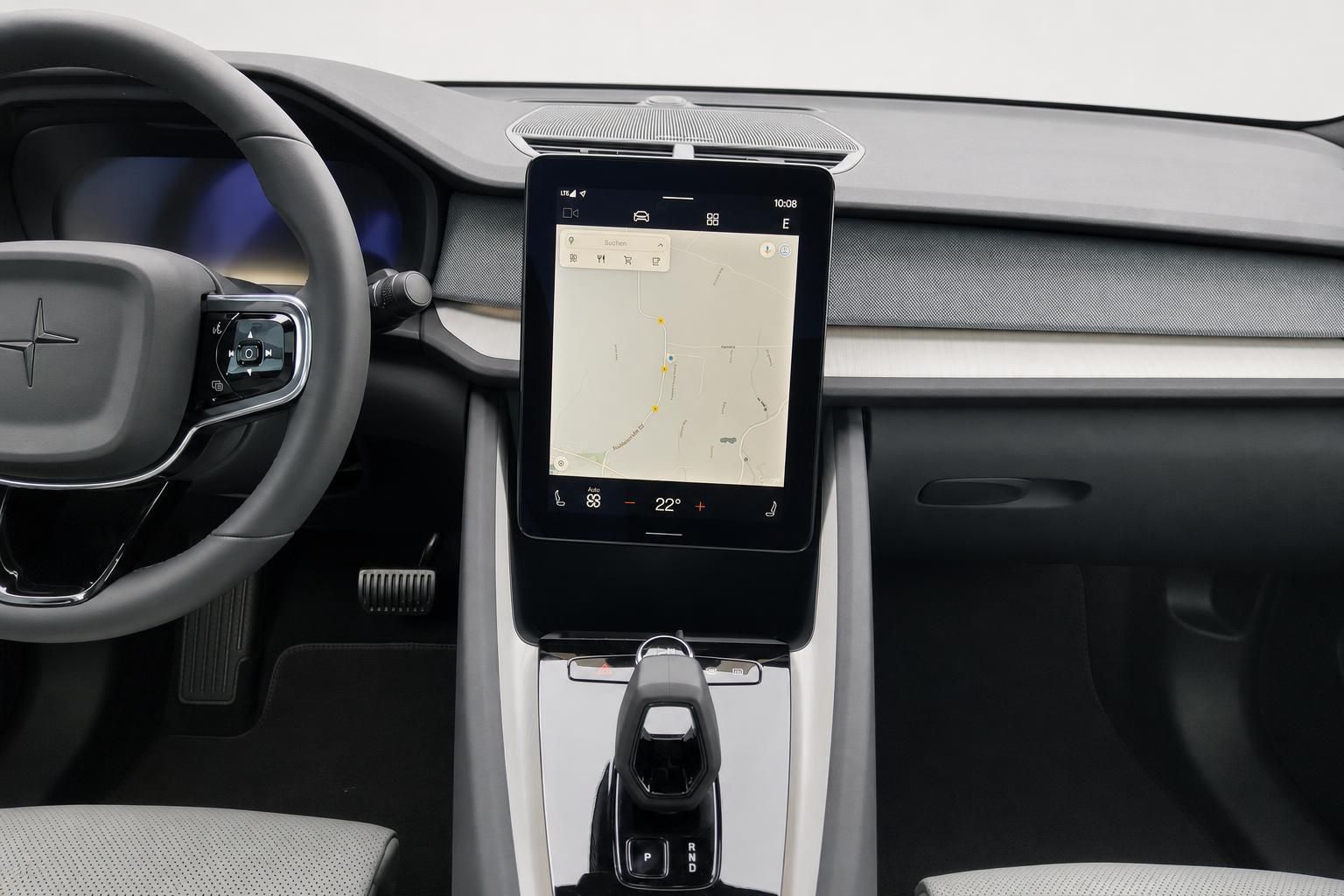 Zentraldisplay mit Navigationskarte und Lenkrad im Fahrzeuginnenraum