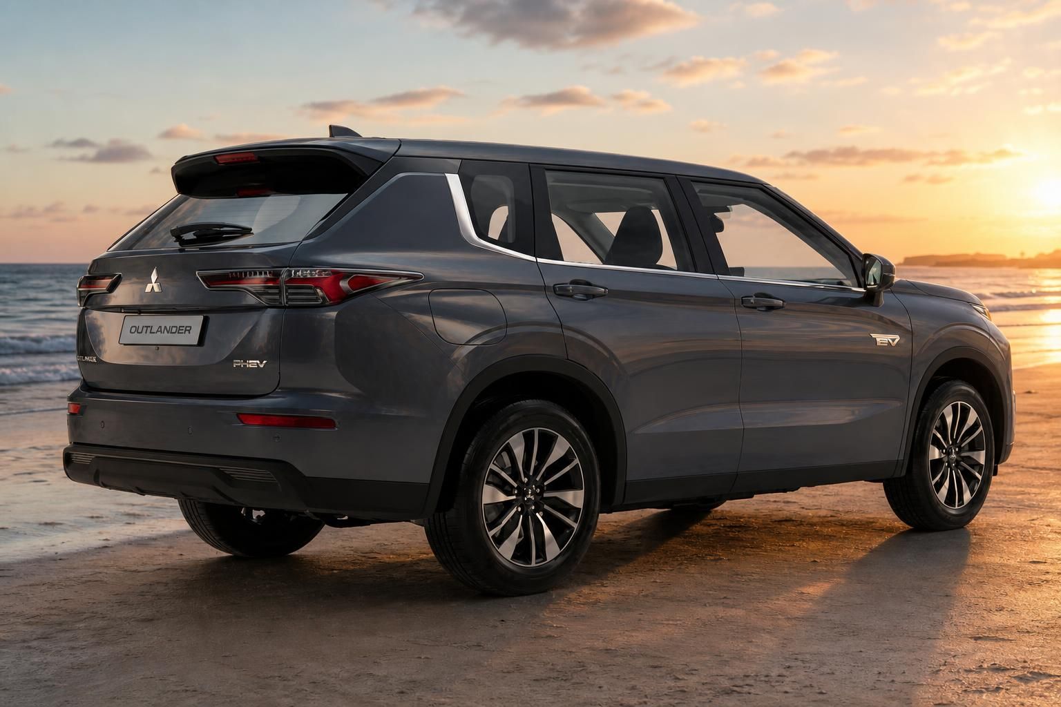 Mitsubishi Outlander PHEV grau, Heck-Seitenansicht am Strand bei Sonnenuntergang