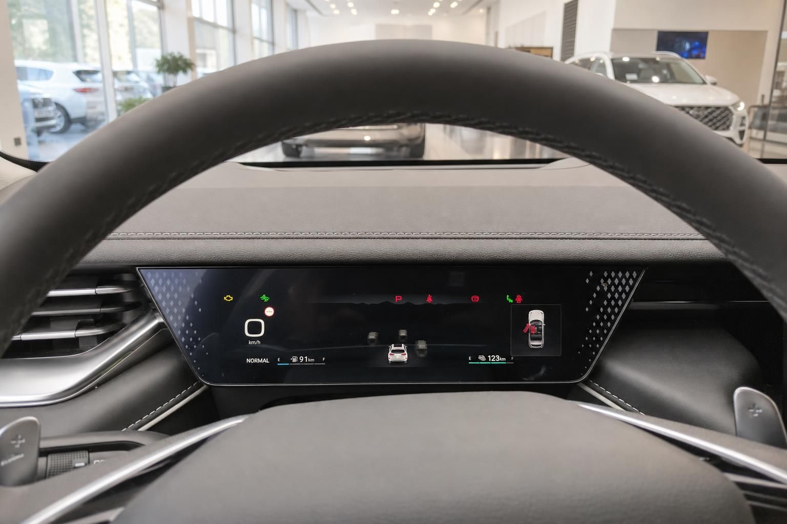 Digitales Kombiinstrument hinter dem Lenkrad eines WEY SUV mit Fahrerassistenzanzeigen