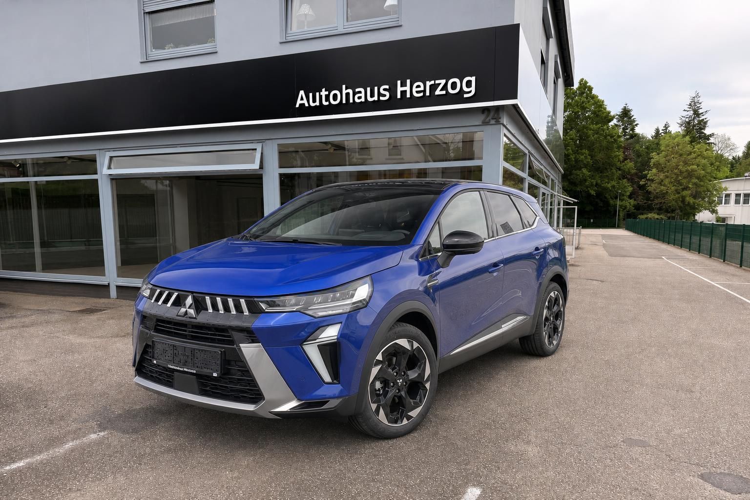 Blauer Mitsubishi SUV vor dem Autohaus Herzog geparkt