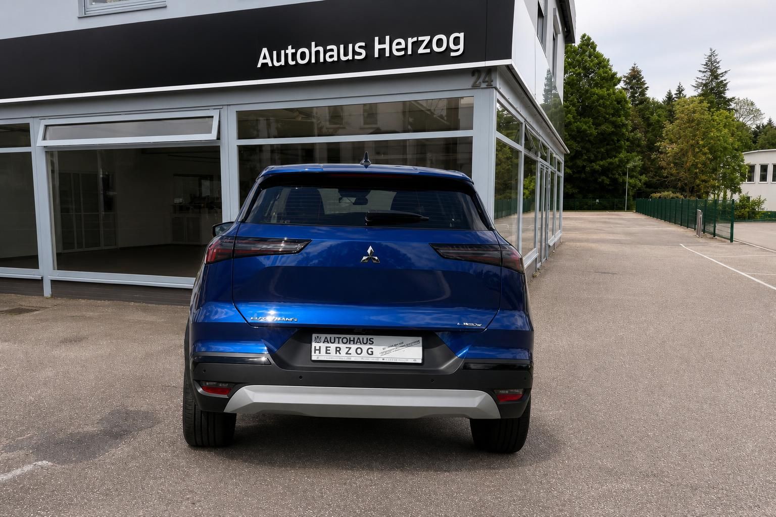 Mitsubishi Grandis blau Heckansicht vor Autohaus Herzog