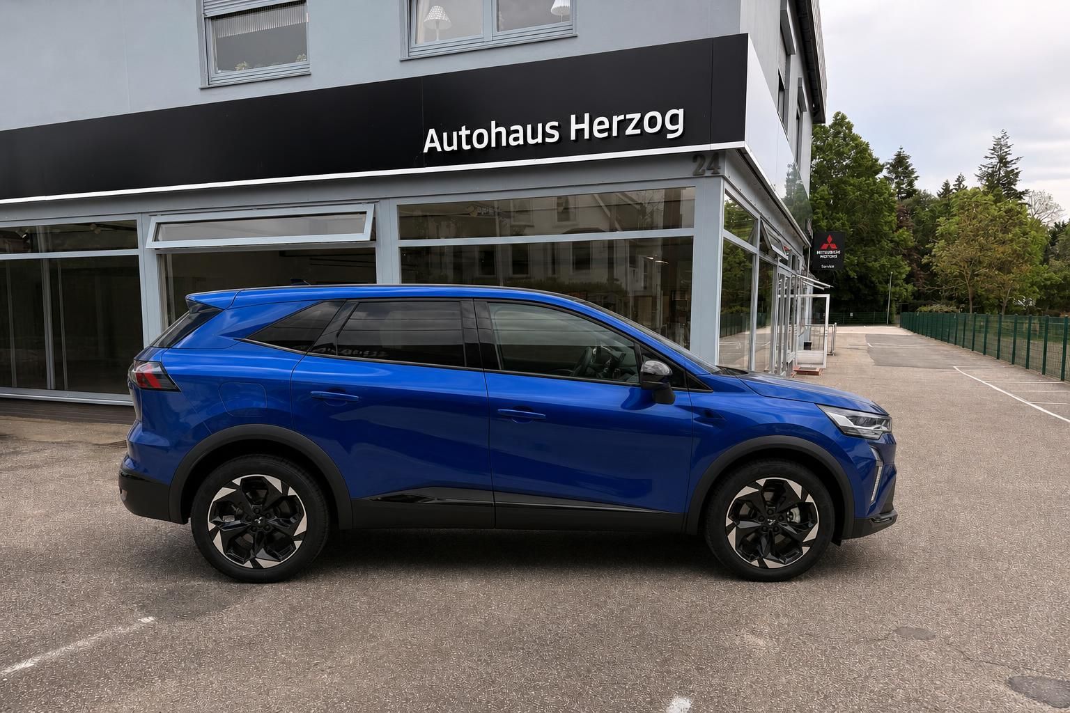 Blauer Mitsubishi SUV Seitenansicht vor Autohaus Herzog