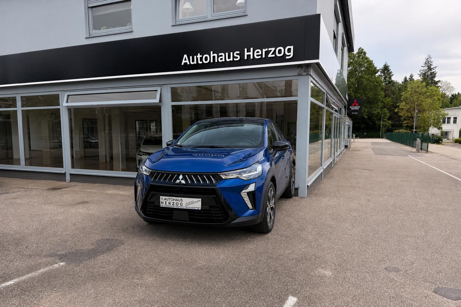Mitsubishi SUV blau Frontansicht vor Autohaus Herzog