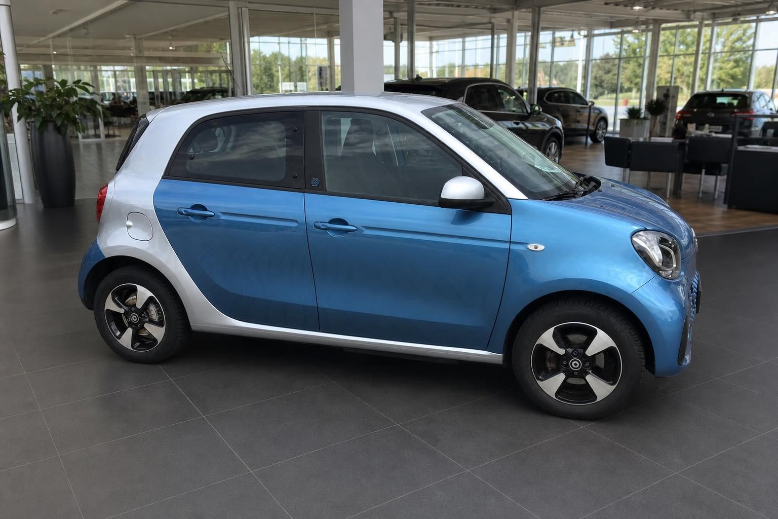 Smart Forfour in Blau-Silber, Seitenansicht im Autohaus Showroom