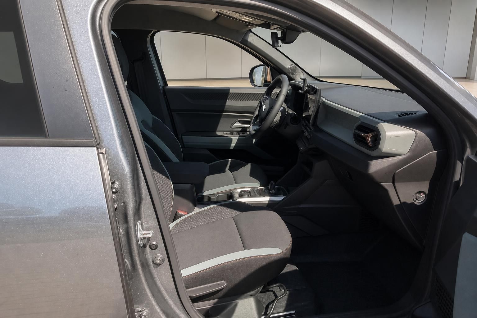 Dacia Duster Innenraum mit Vordersitzen und Armaturenbrett durch offene Tür