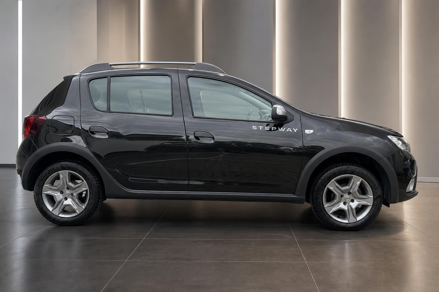 Dacia Sandero Stepway schwarz Seitenansicht im Showroom