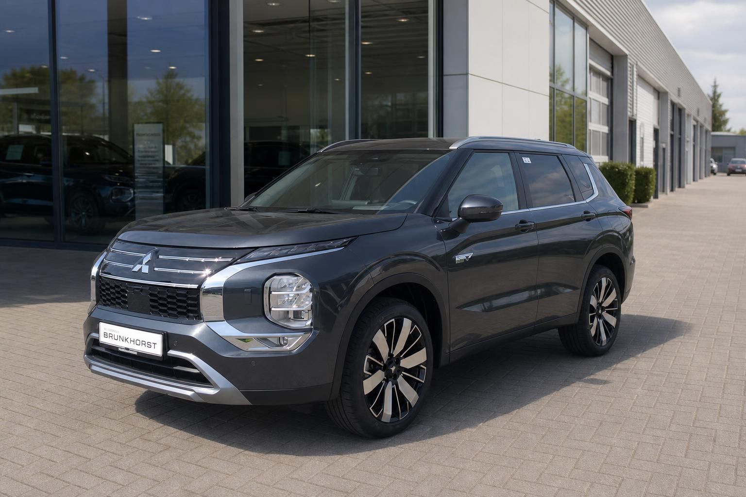 Mitsubishi Outlander PHEV in Grau - Seitenansicht vor Autohaus Brunkhorst