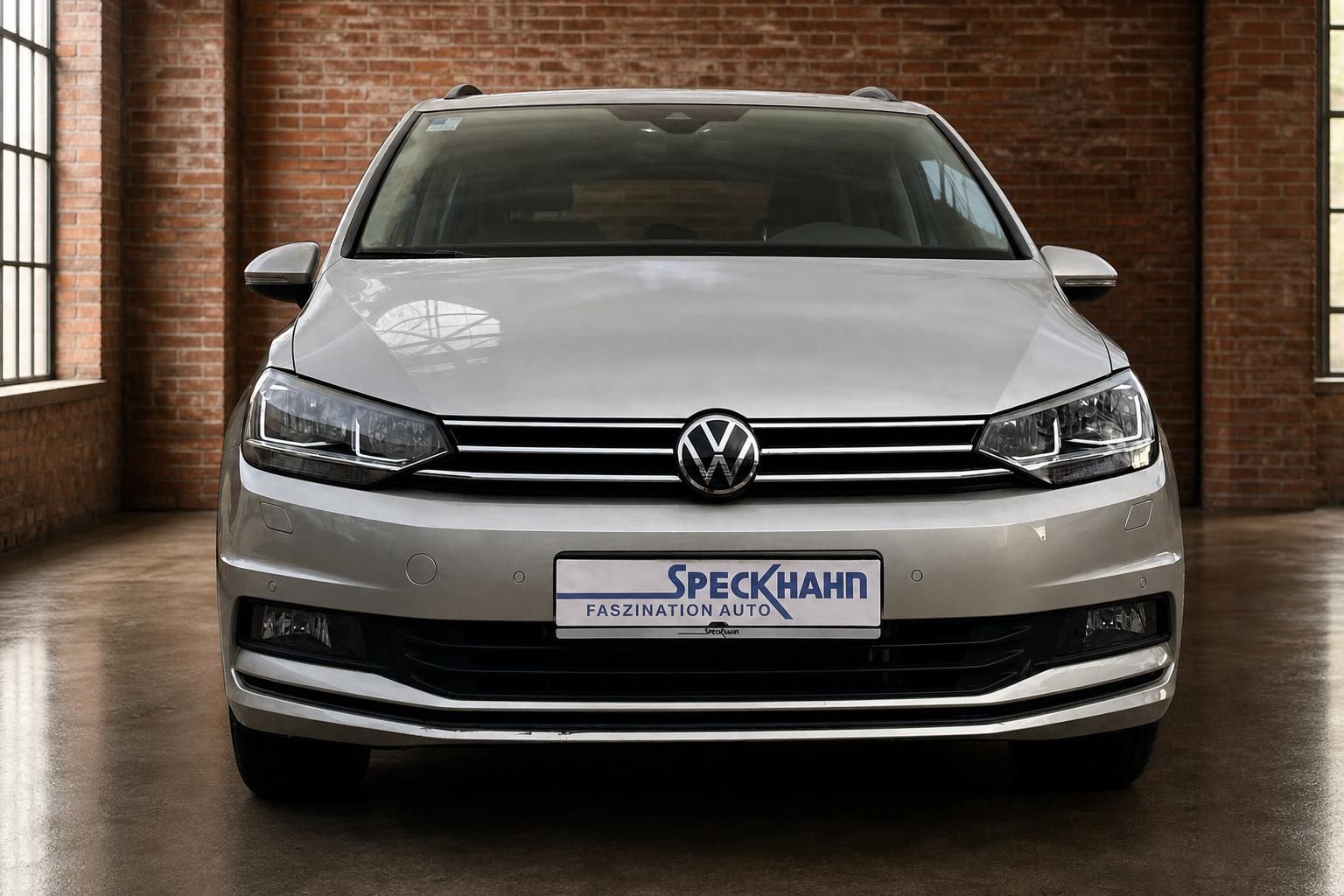 VW Touran silber Frontansicht in Loft-Halle mit Backsteinwand