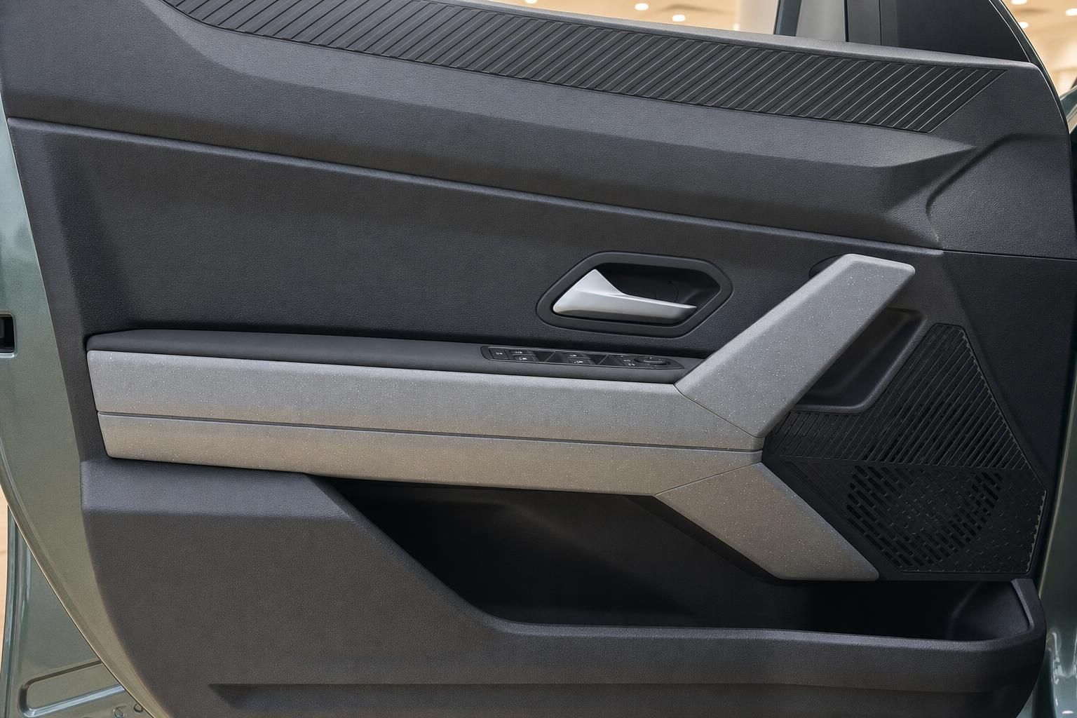 Detailansicht der Türverkleidung mit Fensterhebertasten und Türgriff