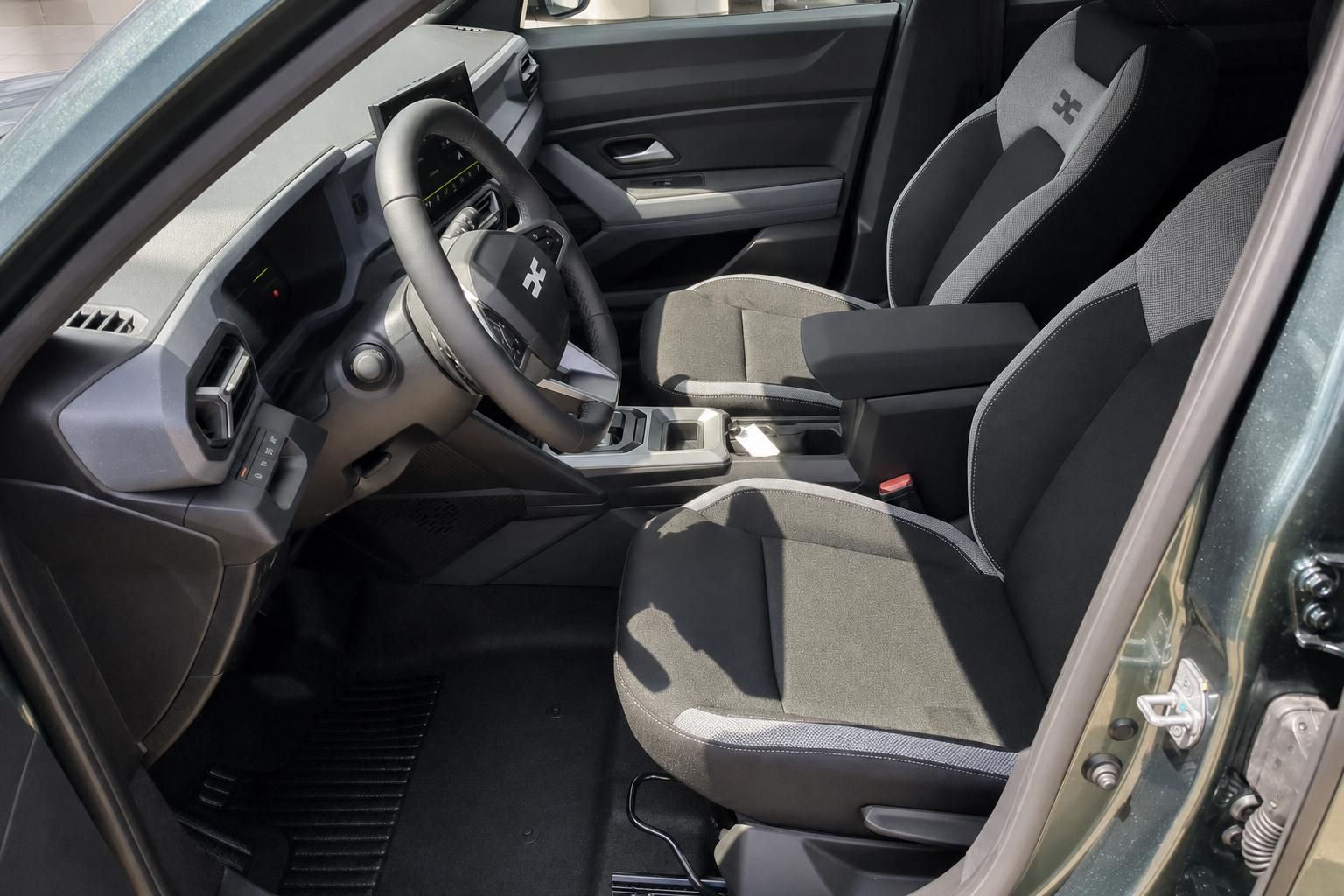 Dacia Duster Innenraum mit Vordersitzen und Lenkrad, Blick durch Fahrertür