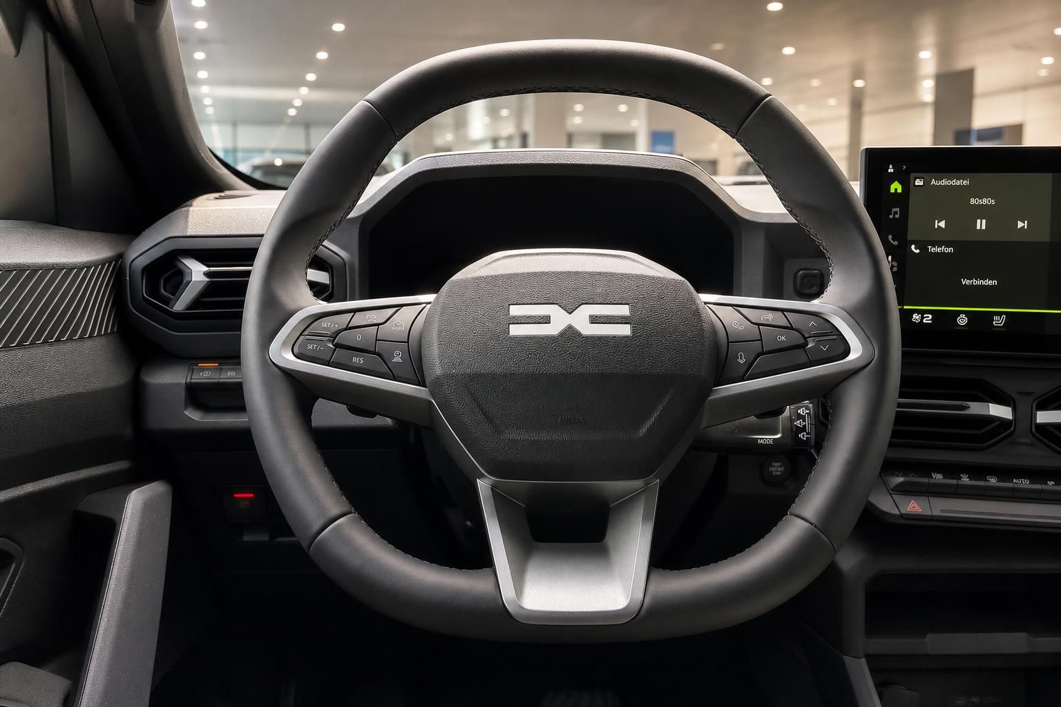 Dacia Lenkrad mit Multifunktionstasten und Infotainment-Display im Innenraum