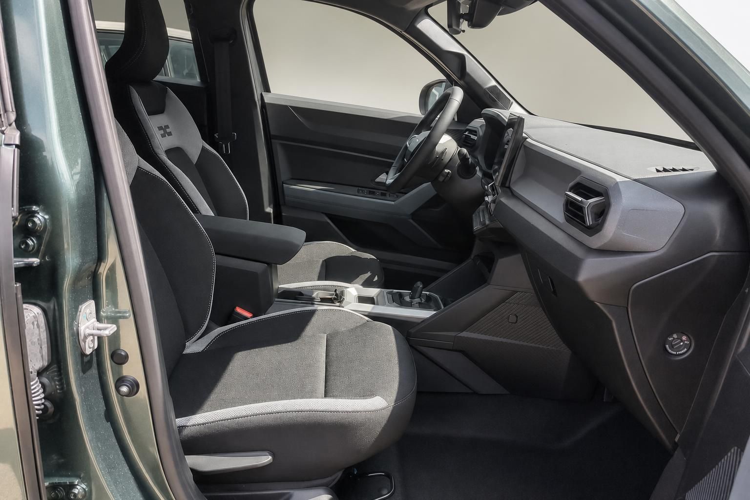 Vordersitze und Cockpit im Innenraum eines grünen Dacia SUV
