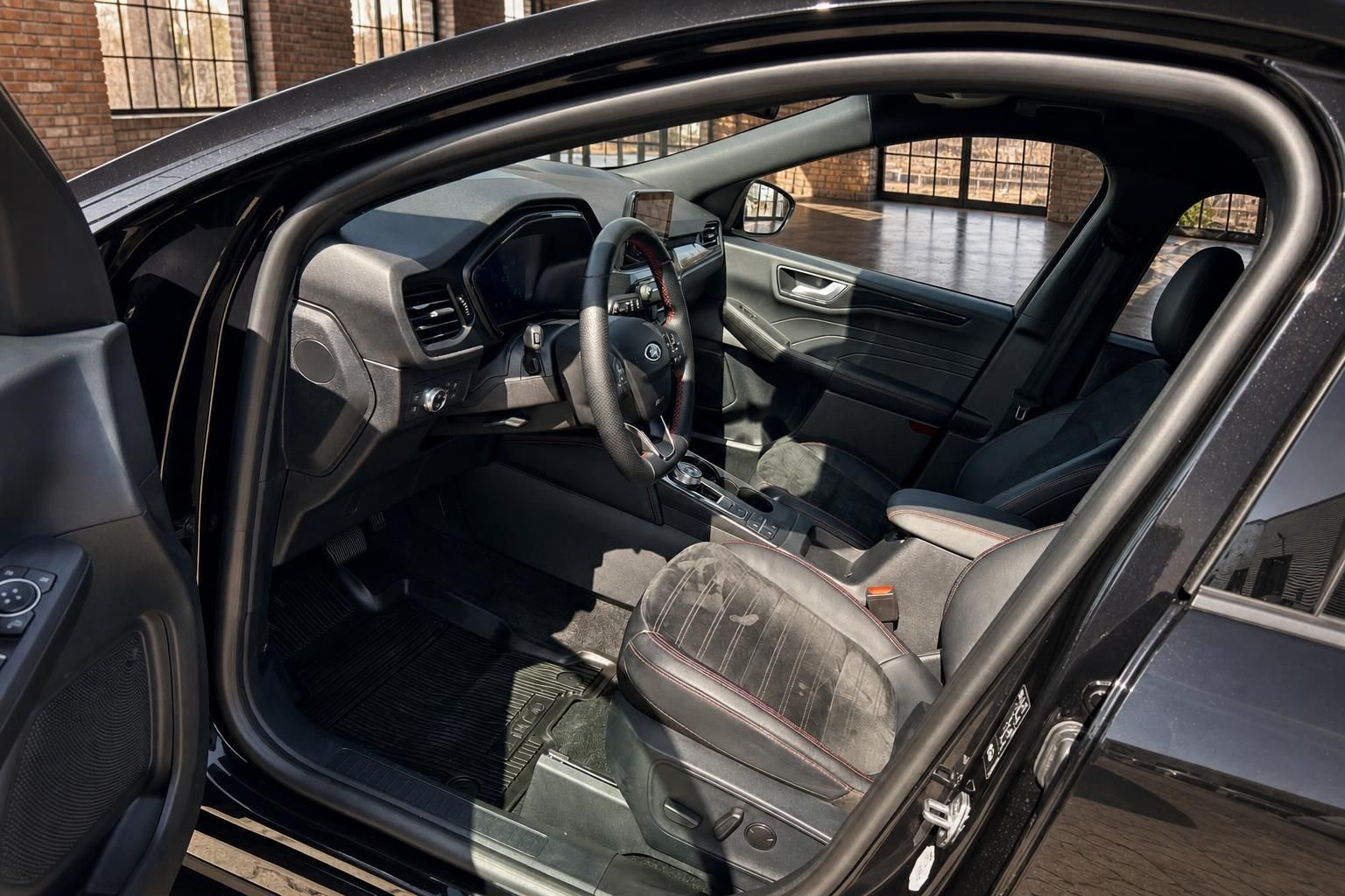 Blick durch geoeffnete Tuer auf Ford Cockpit und Vordersitze