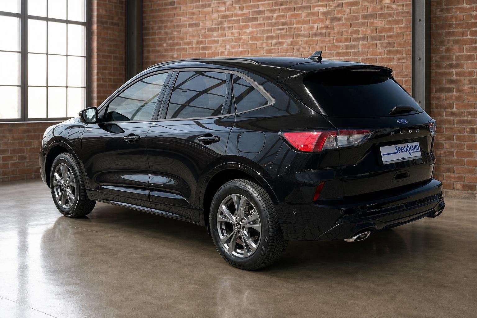 Ford Kuga schwarz Heckansicht seitlich in Industrie-Ambiente