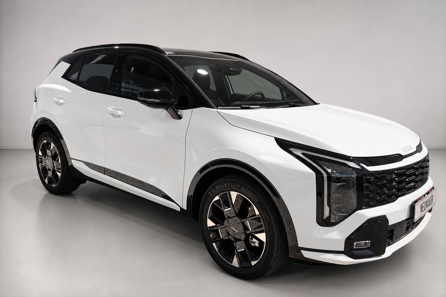 Kia Sportage weiß, Frontansicht schräg mit Kia-Emblem im Studio