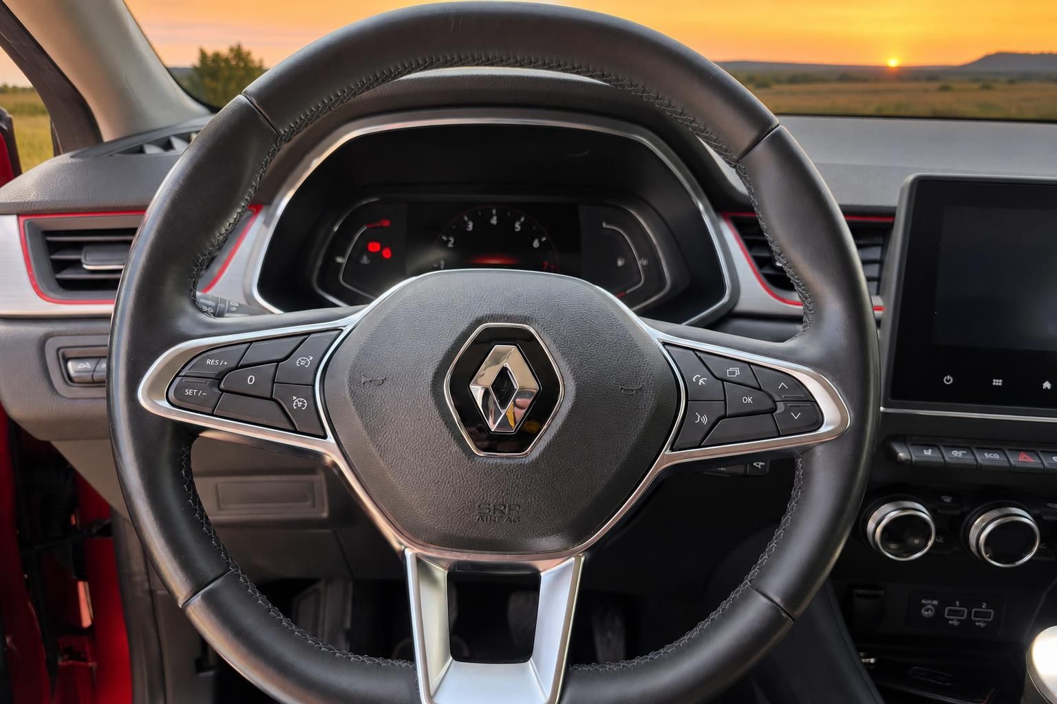 Renault Lenkrad mit Cockpit und Multifunktionstasten bei Sonnenuntergang