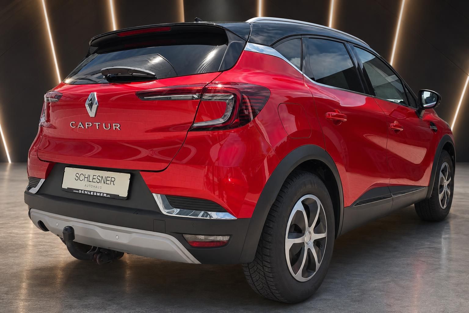 Roter Renault Captur SUV, Heck-Seitenansicht mit Anhaengerkupplung