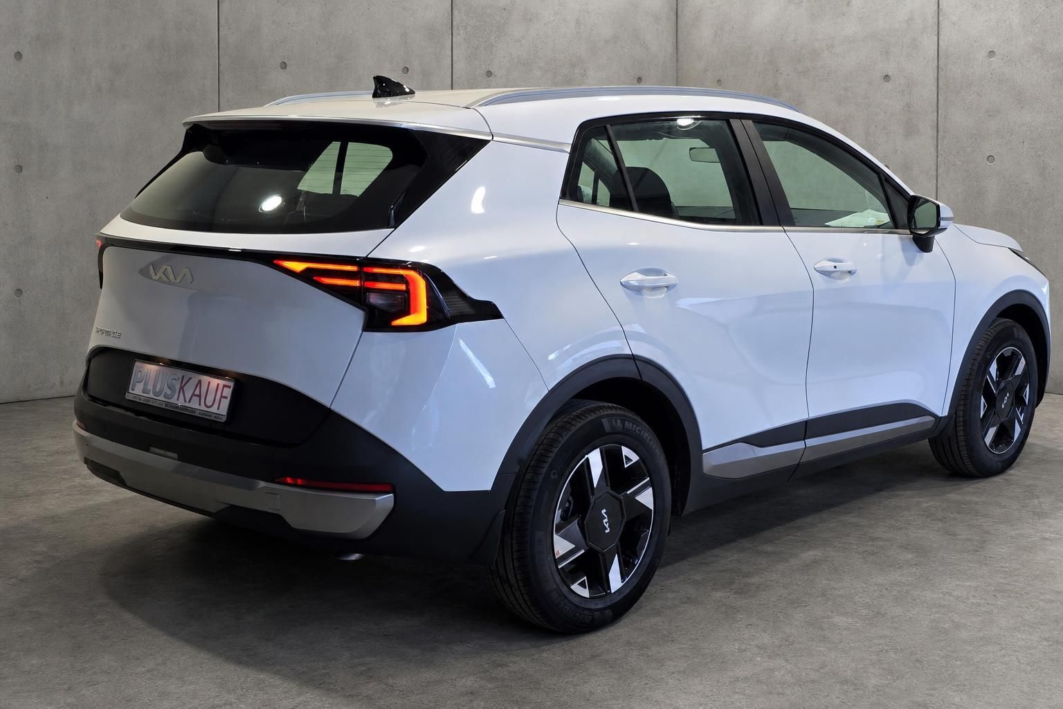 Kia Sportage weiß Heckansicht seitlich in Studioumgebung