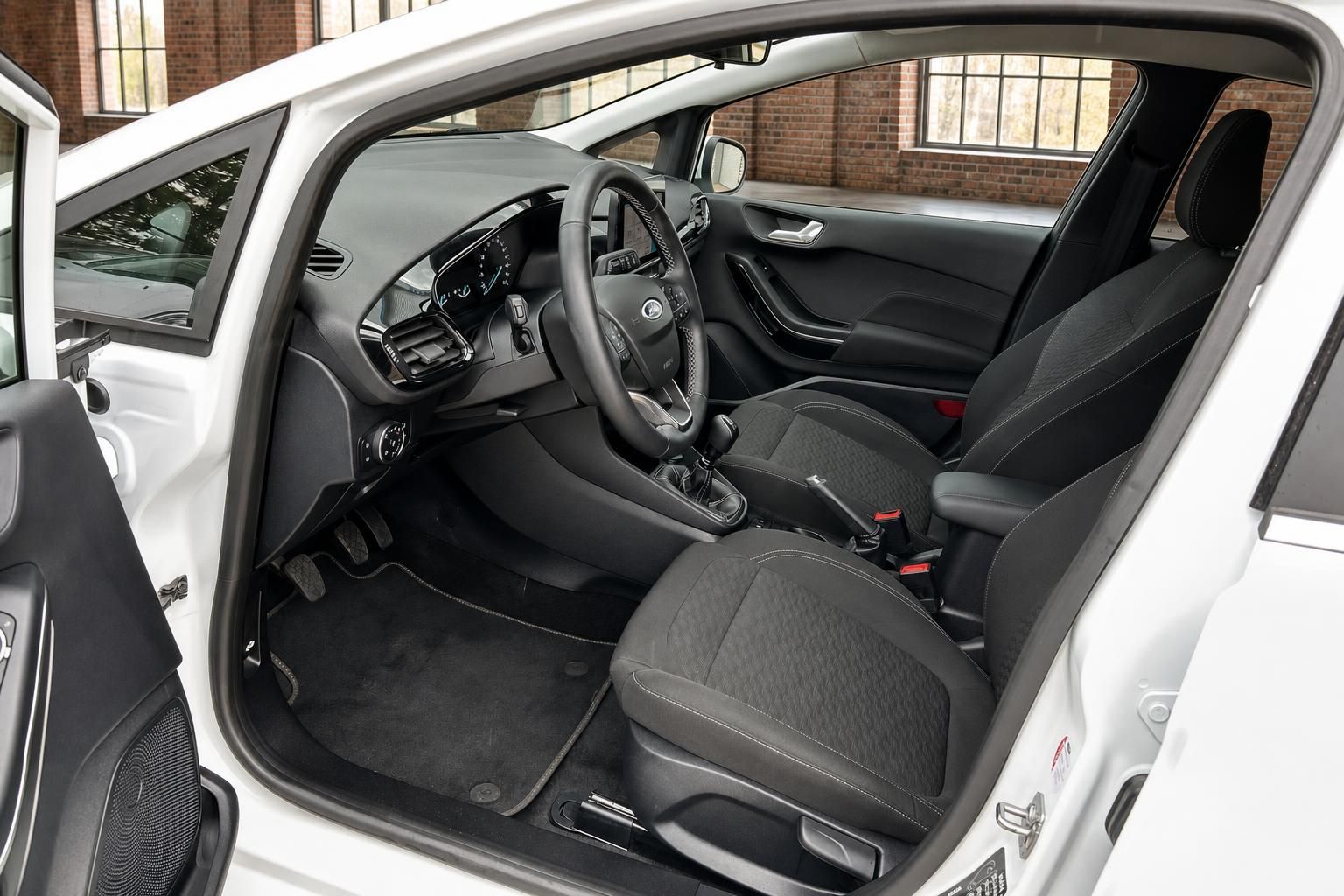 Ford Fiesta Innenraum Fahrerseite mit Lenkrad Schaltgetriebe und schwarzen Stoffsitzen